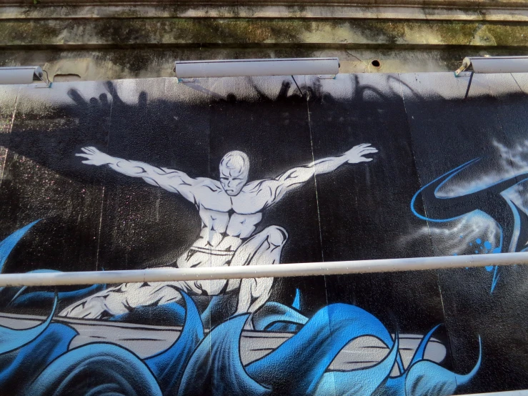 the mural depicts a man holding his arms wide open