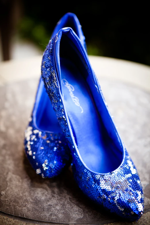 blue shoes with sequins on them laying on the table