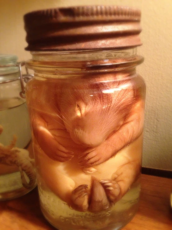 a jar filled with liquid on top of a wooden table