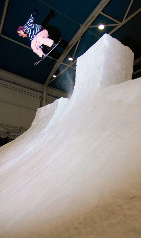 a snowboarder jumping over a white slope