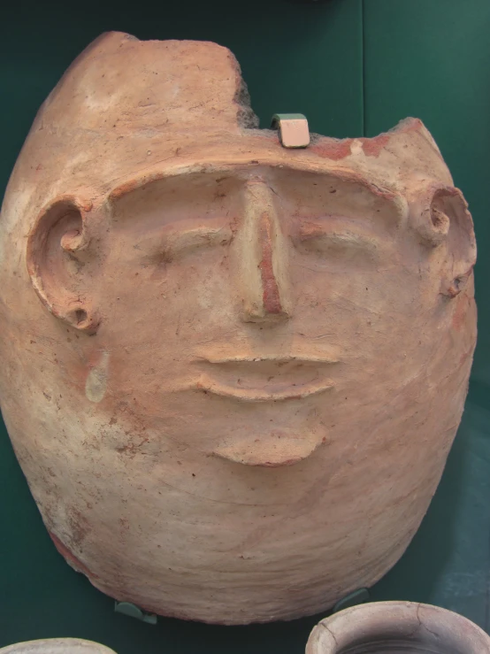 a stone face with two pieces in the background