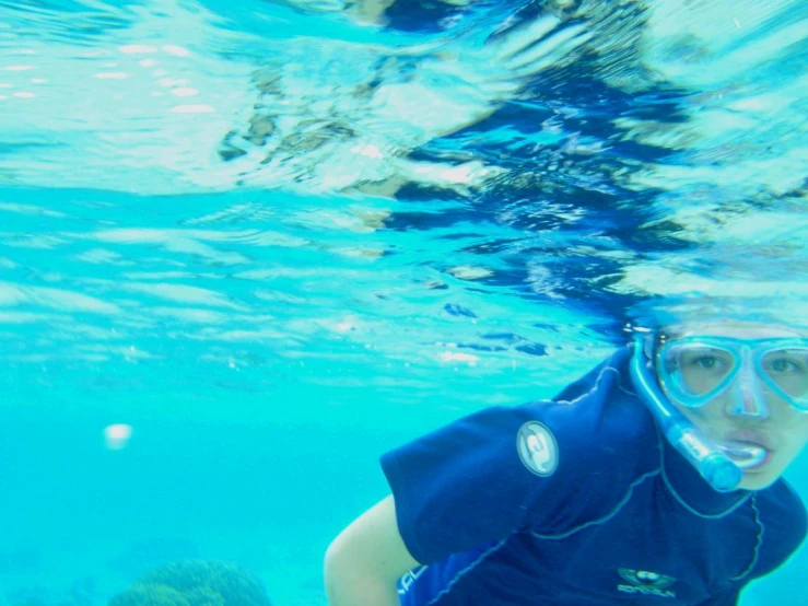a woman scubas with snorggles and in the ocean