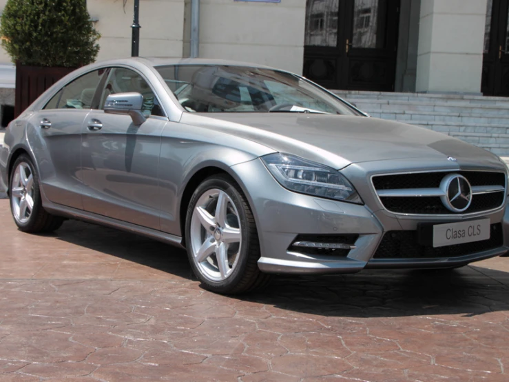 a silver mercedes car parked in front of a building