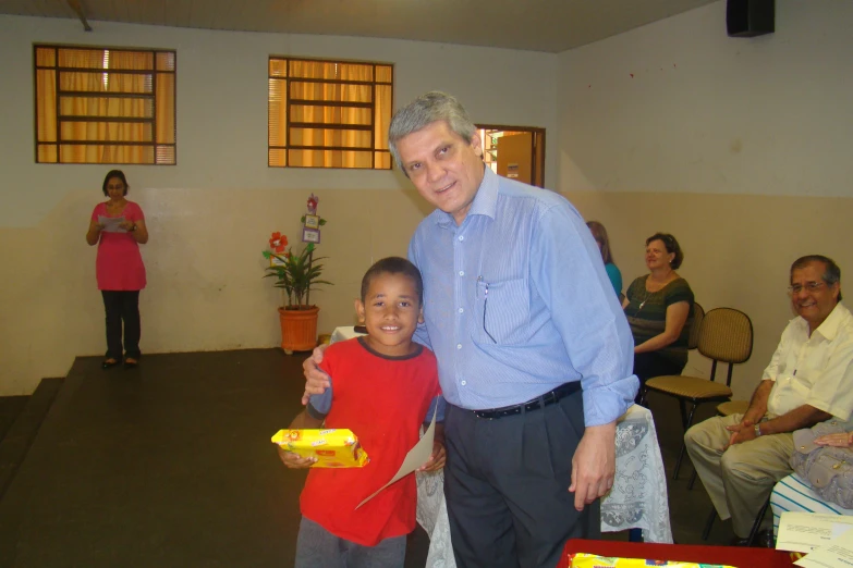 a man holding a child in a room full of people