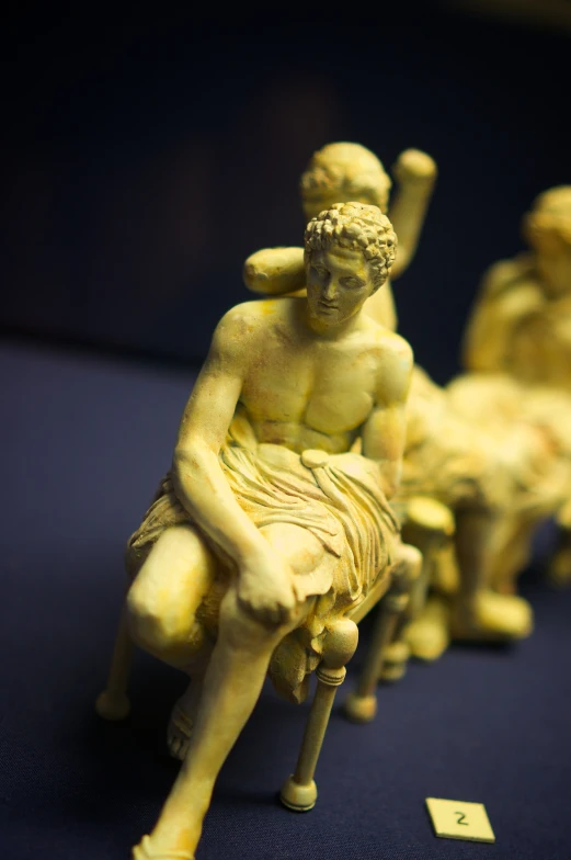 a group of small statues of men sitting down