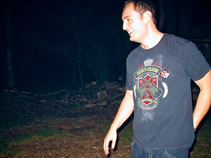 a young man standing outside in the dark