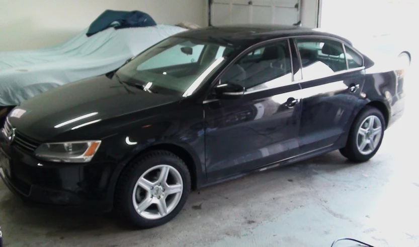 a dark colored audi sedan in a car garage