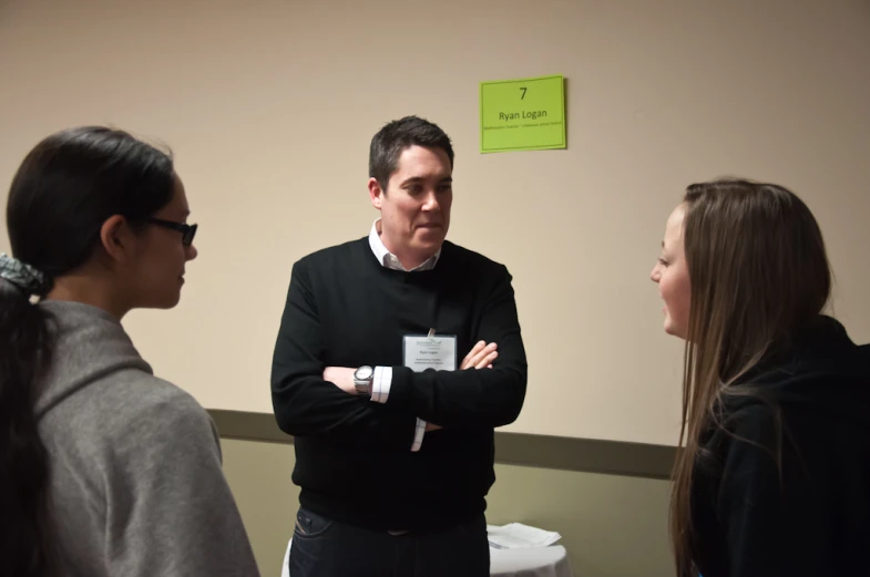 three woman are talking to a man while he looks at them