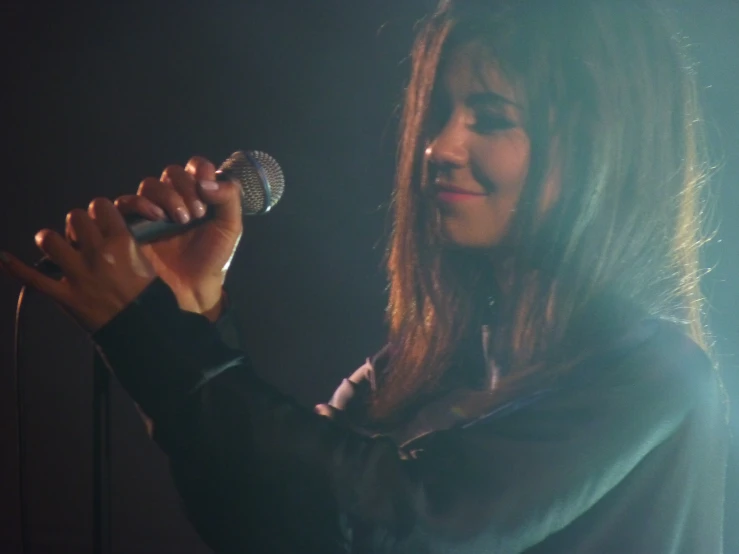 a woman on stage holding a microphone up