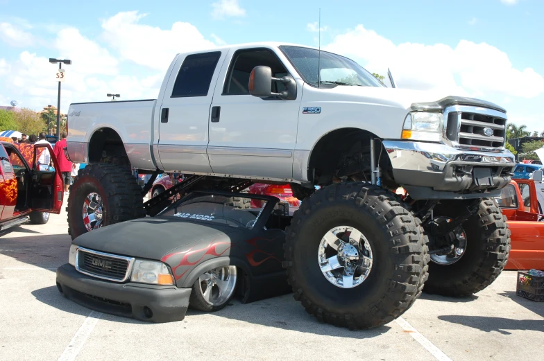 a huge truck sitting parked in a lot with a person sitting next to it