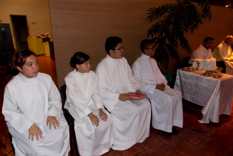 seven women wearing white dresses and white hair sit together