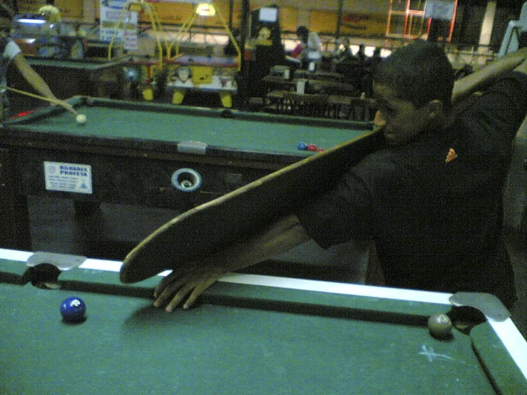 a man is leaning on the edge of a pool table