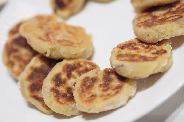 a few small pancakes stacked in rows on a plate