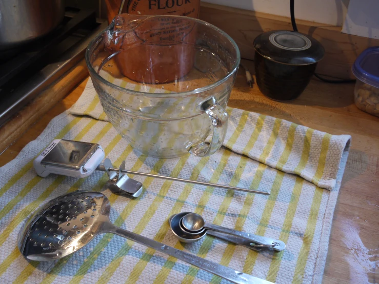 a counter with an ice bucket, spoons and other kitchen utensils