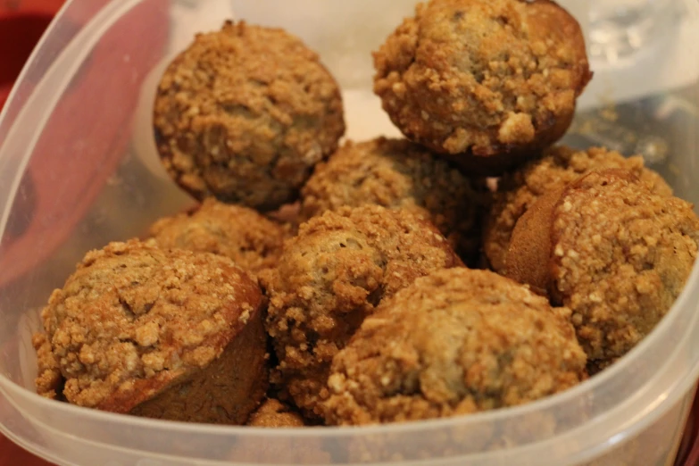 a clear plastic container full of chocolate muffins