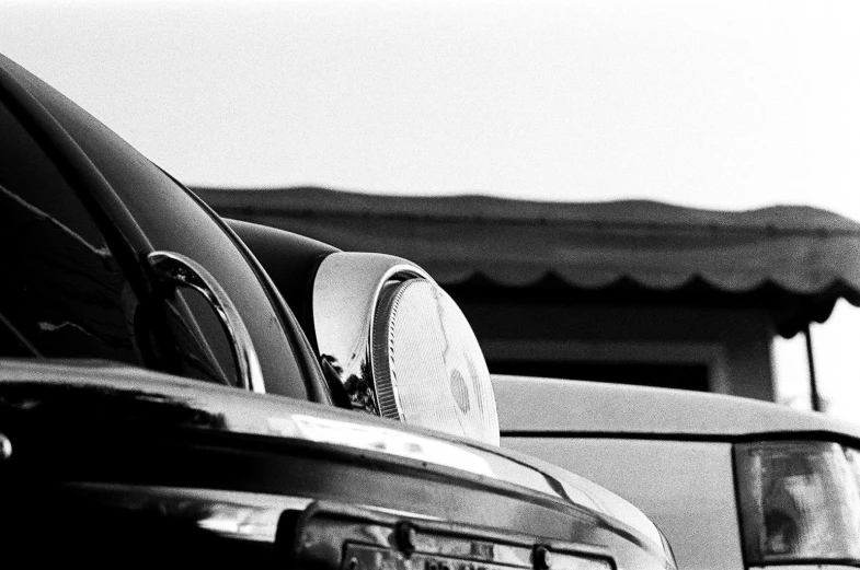 a rear view mirror sitting on the trunk of a parked car