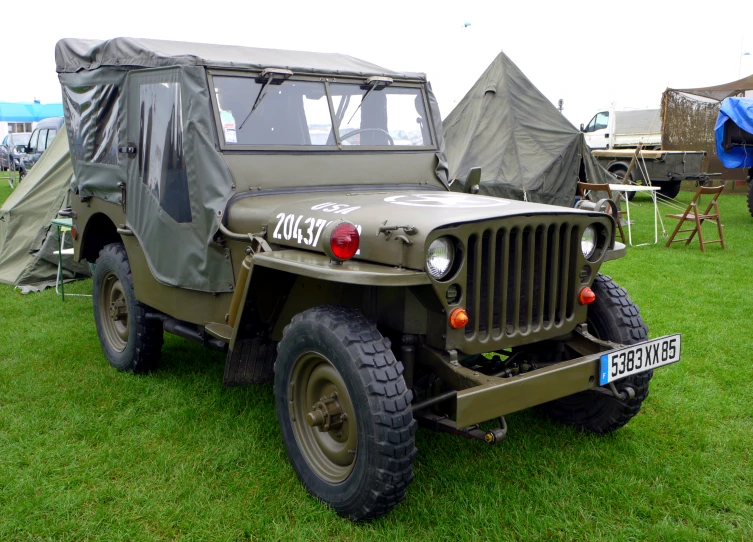 an army jeep that is parked on some grass