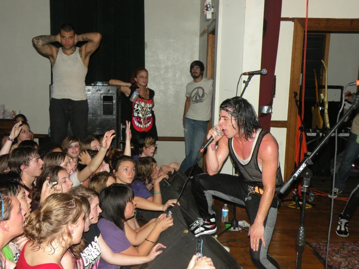 a man with a guitar in front of a crowd of people