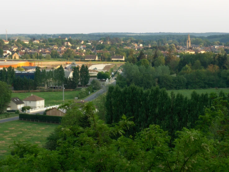 a town and trees are on the other side of the river
