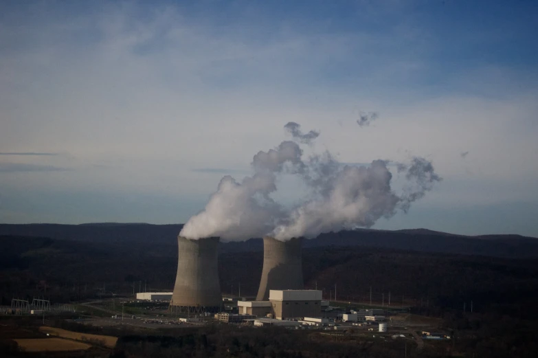 smokestacks emits from cooling towers atop a city