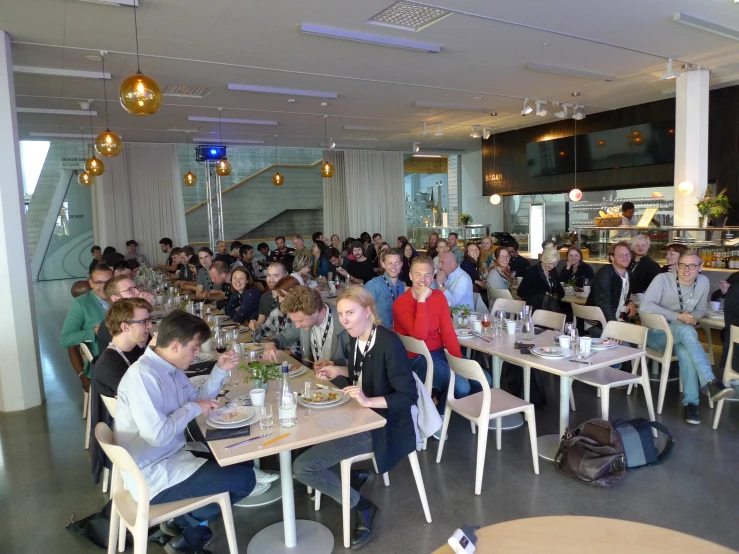 a restaurant filled with people sitting at different tables