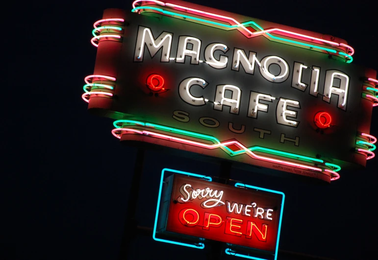 a neon sign with an open sign on top of it