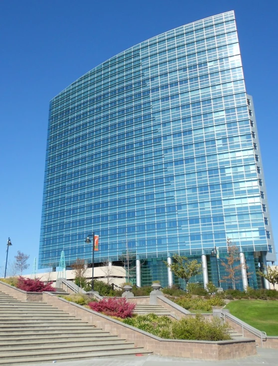 modern building with blue glass facade in front of grassy area