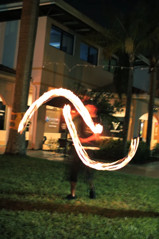 light painting in front of a el building with person holding light stick