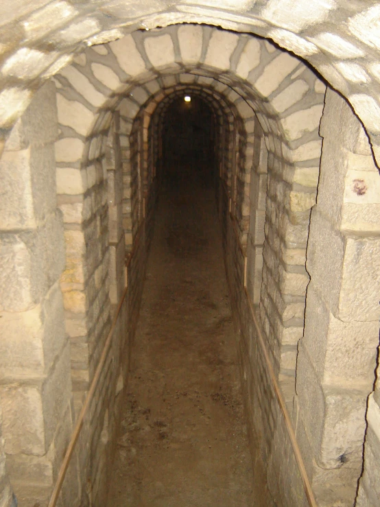 an archway leading into an underground area that contains dirt and a concrete wall
