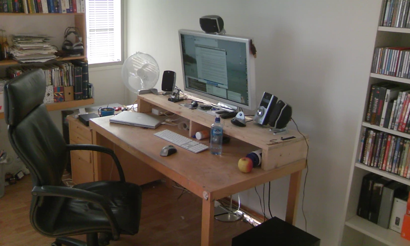 a chair sits at the desk where there is a computer monitor on