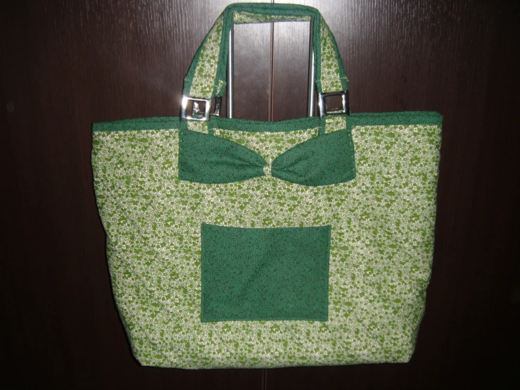 an oversize purse has a green flower print