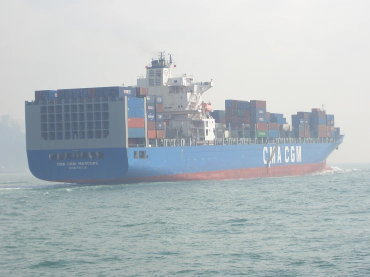 a large blue cargo ship in the middle of the ocean