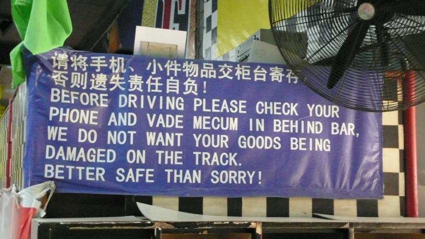 a blue sign that says before driving please check your phone and vade meom in behind bar