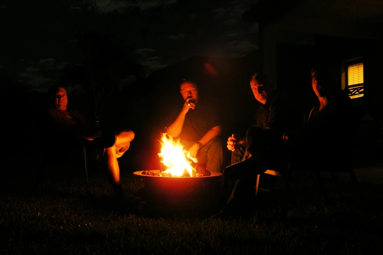 people sitting around a campfire at night