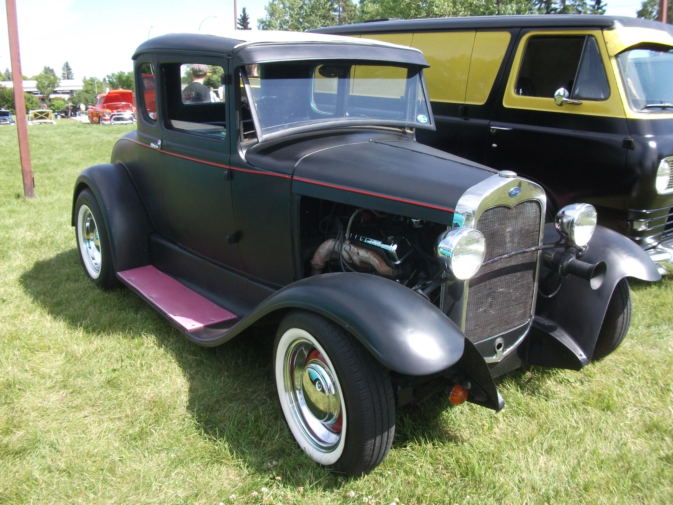 a truck sitting next to another old one on a grassy field