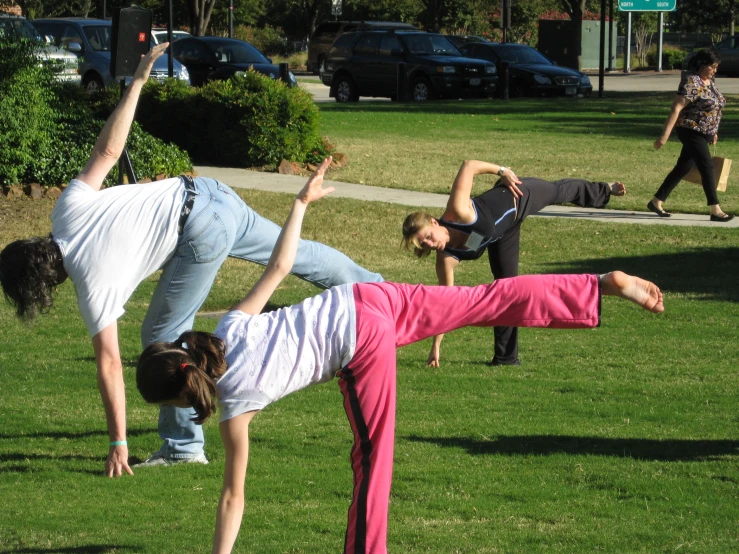 a group of young women in the grass doing exercises