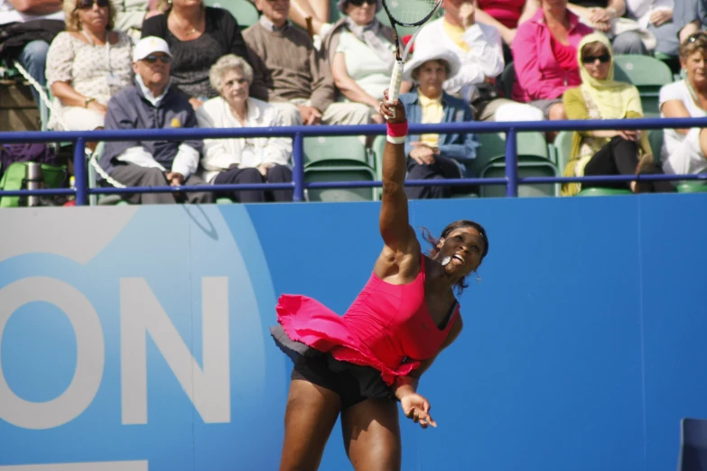 a woman tennis player serves the ball during a match