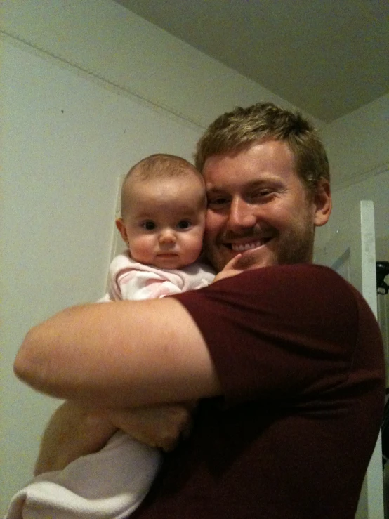 a man and child smile while they hold one another