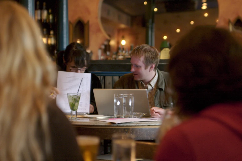 the two women are at a small table with papers