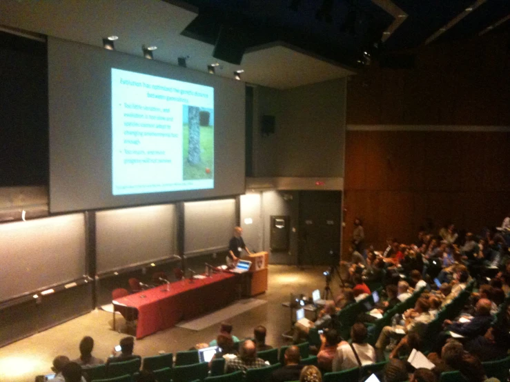 a full auditorium at an university lecture hall with tables and computers