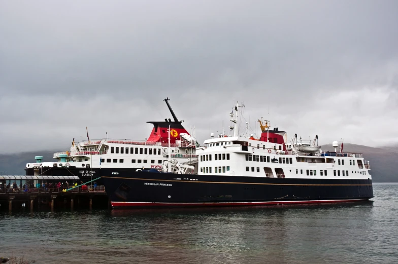 large ship docked at dock in cloudy sea water