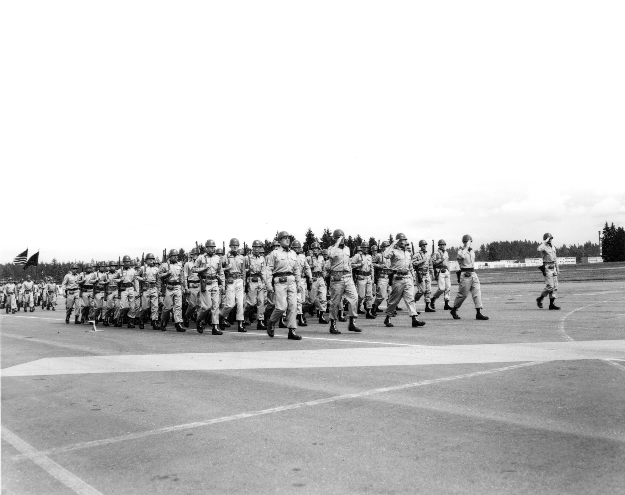 a large military parade on a cement field