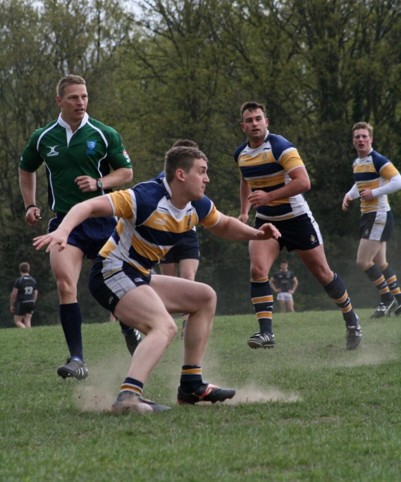 men running and playing rugby on the grass