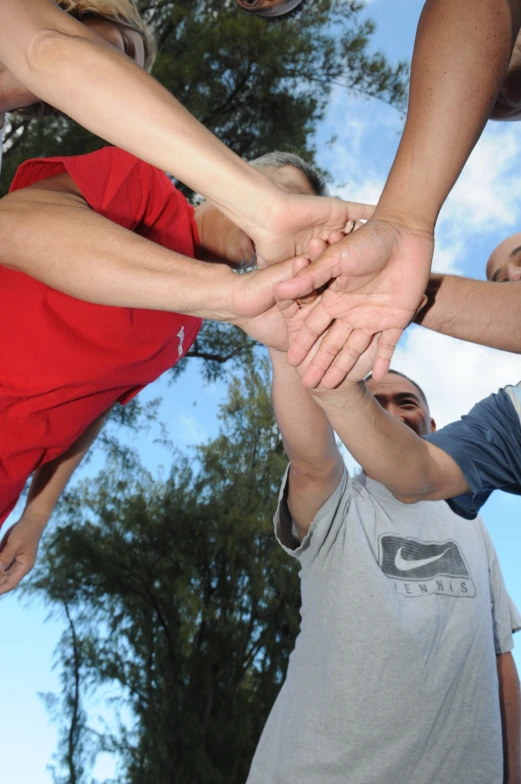 people holding their hands in a circle together