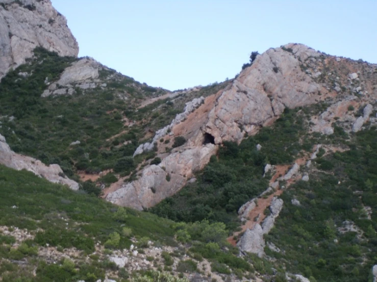 a rocky hillside with a tree filled valley