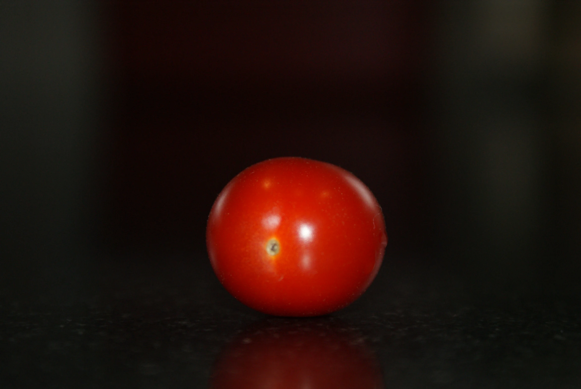 a single tomato sitting on the top of the table