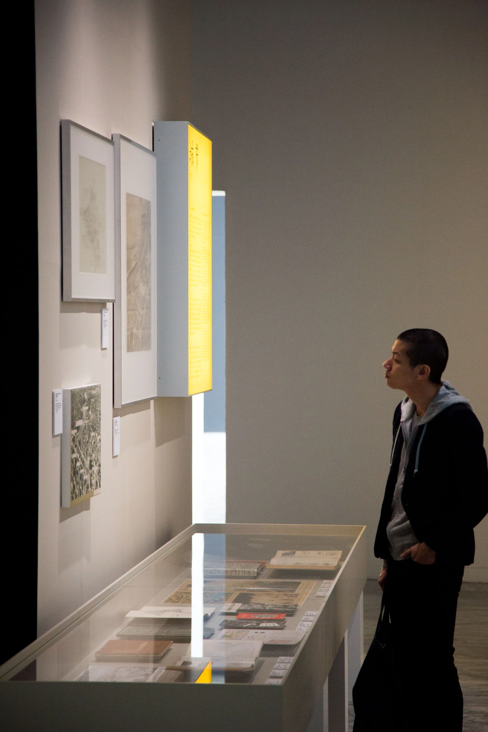 man standing in front of a white display on one side and yellow rectangle with some other on the other side