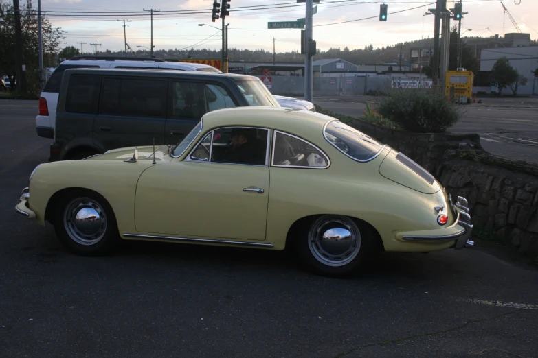 an older yellow vw bug driving on a road