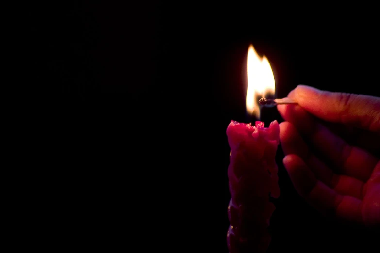 a hand holding soing with a matchstick