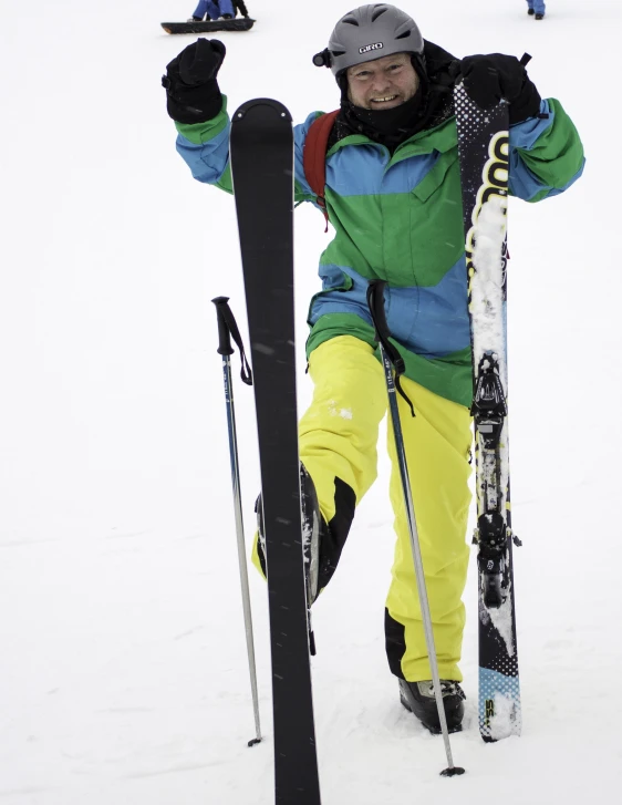 there is a man standing in the snow holding some skis